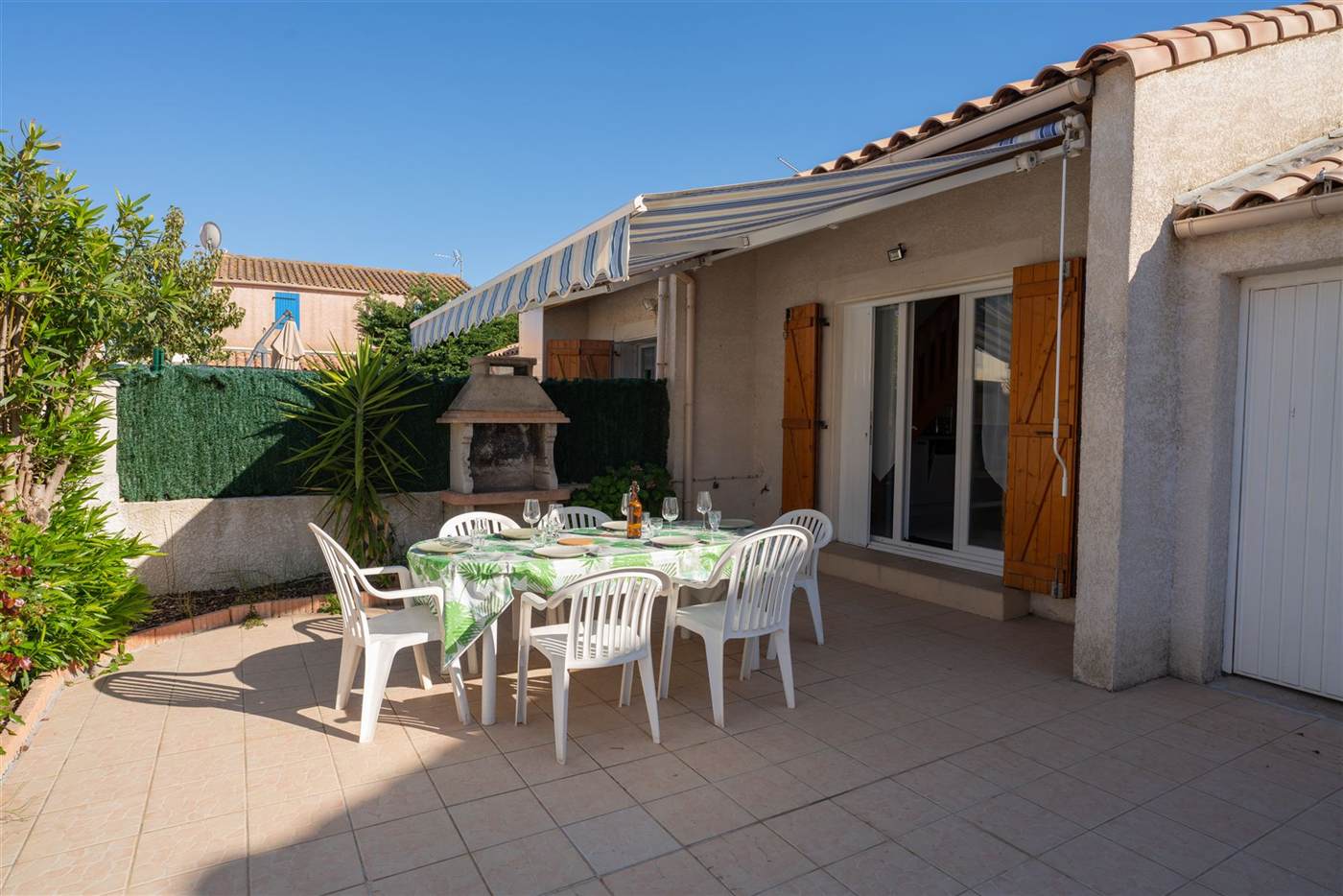 Terrasse sous auvent, table dressée en fin de journée