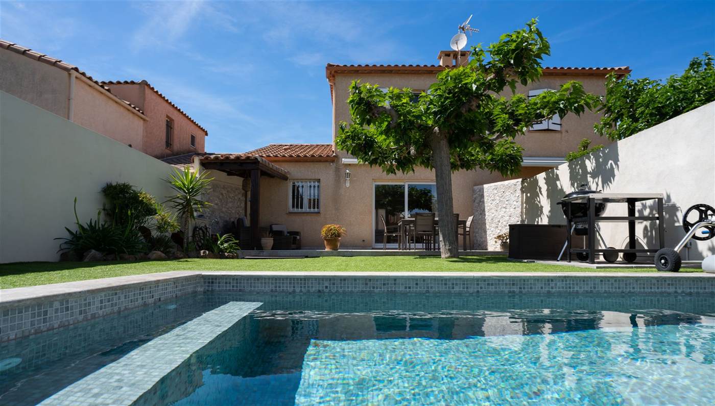 Piscine avec grand arbre et façade méditerranéenne