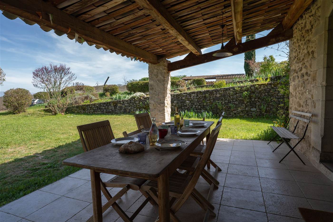 Terrasse couverte, table dressée, vue sur la campagne